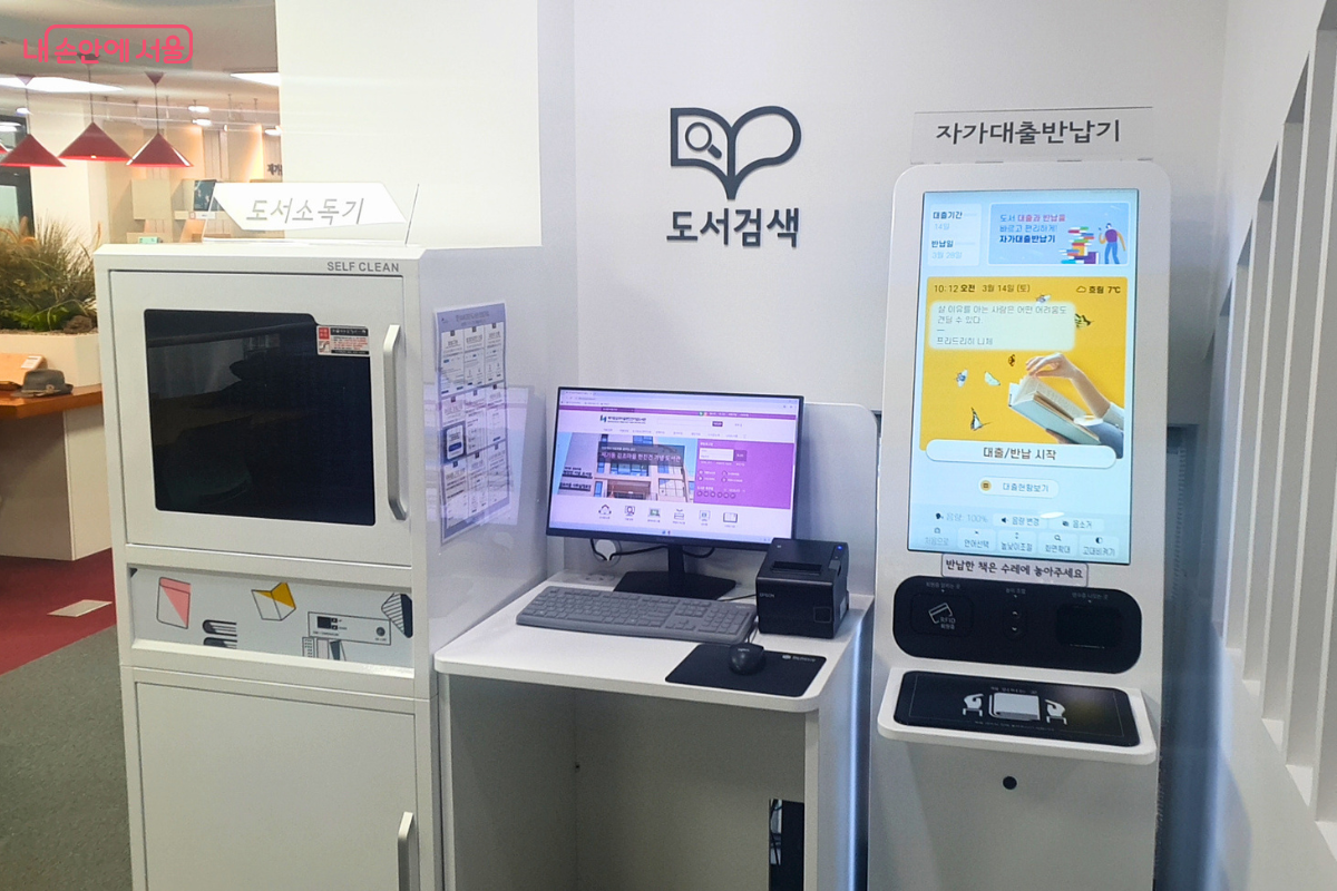 4층 제1열람실 내부에 설치된 도서 이용 편의 장비들의 모습이다. 왼쪽에는 도서를 위생적으로 관리하는 '도서 소독기'가 있고, 중앙에는 도서 위치를 찾는 검색용 컴퓨터가 배치되어 있다. 우측의 '자가 대출 반납기' 화면에는 철학자 니체의 명언과 함께 대출 및 반납 시작을 안내하는 화면이 떠 있어 시민들의 편리한 도서 이용을 돕는다.