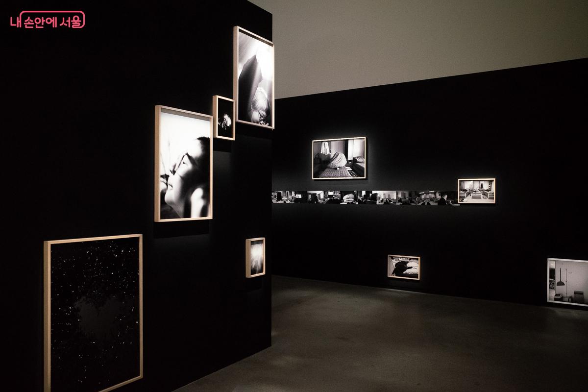 검은 벽면을 따라 다채로운 시각적 서사가 흐르는 전시 공간 &copy;이란