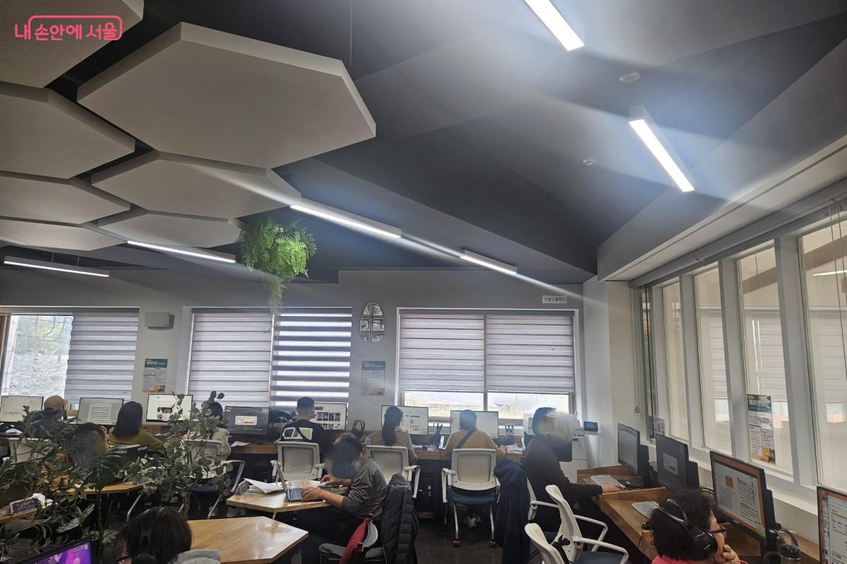 2층 디지털라운지의 모습이다. 컴퓨터가 10대 이상 비치되어 있다. 이용객들은 비치되어 있는 컴퓨터를 사용하거나 개인 노트북을 지참하는 등 자율적으로 라운지를 이용하는 모습을 확인할 수 있다.