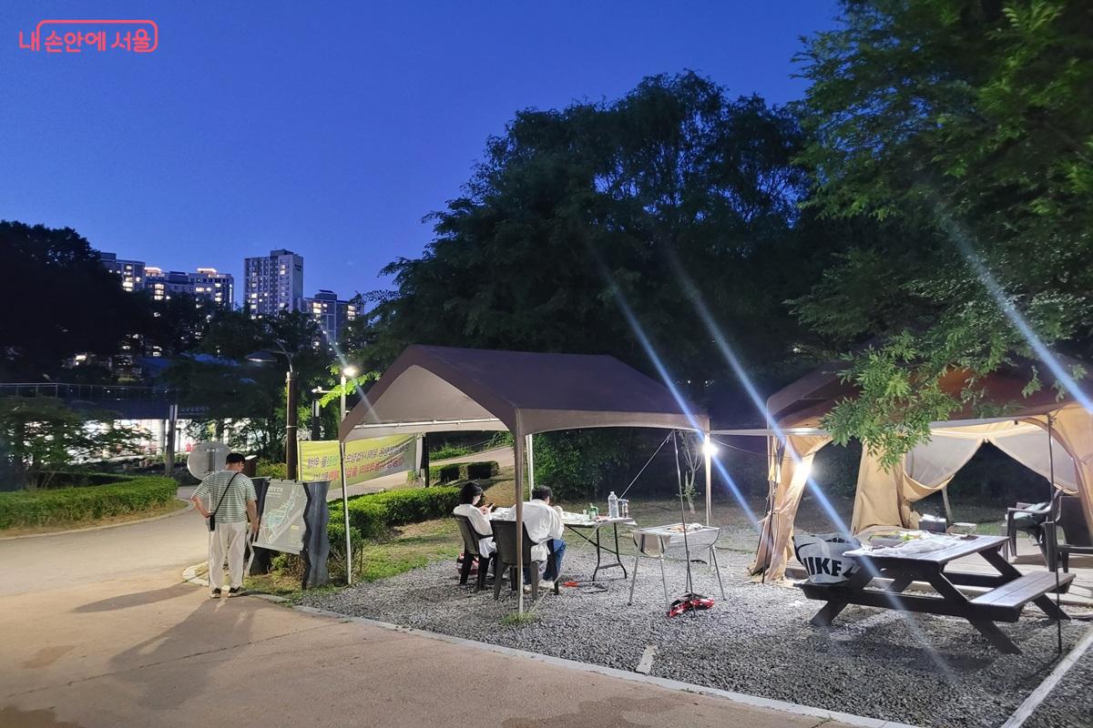 중랑가족캠핑장, 텐트 조명 아래 둘러앉아 하루를 마무리하고 있다. &copy;조연