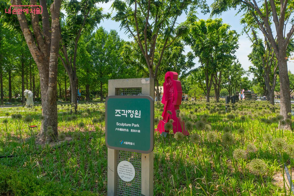 많은 조각 작품들이 꽃과 나무 사이에 설치되어 있는 조각정원