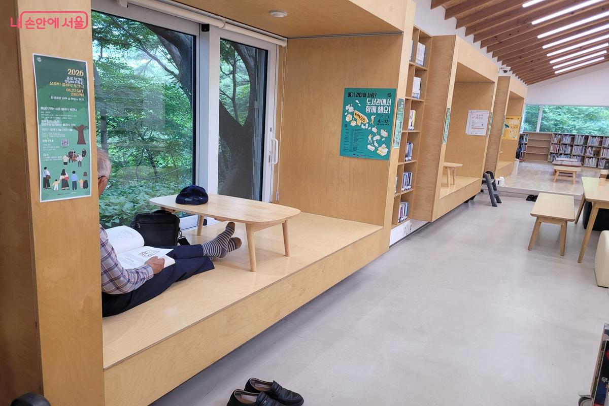 창가 좌식 독서 공간에서 신발을 벗고 편안하게 책을 읽는 모습 &copy;조연