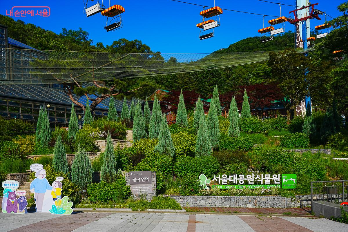 서울대공원 식물원 외관, 기획전 입간판, 체어리프트가 지나가는 배경