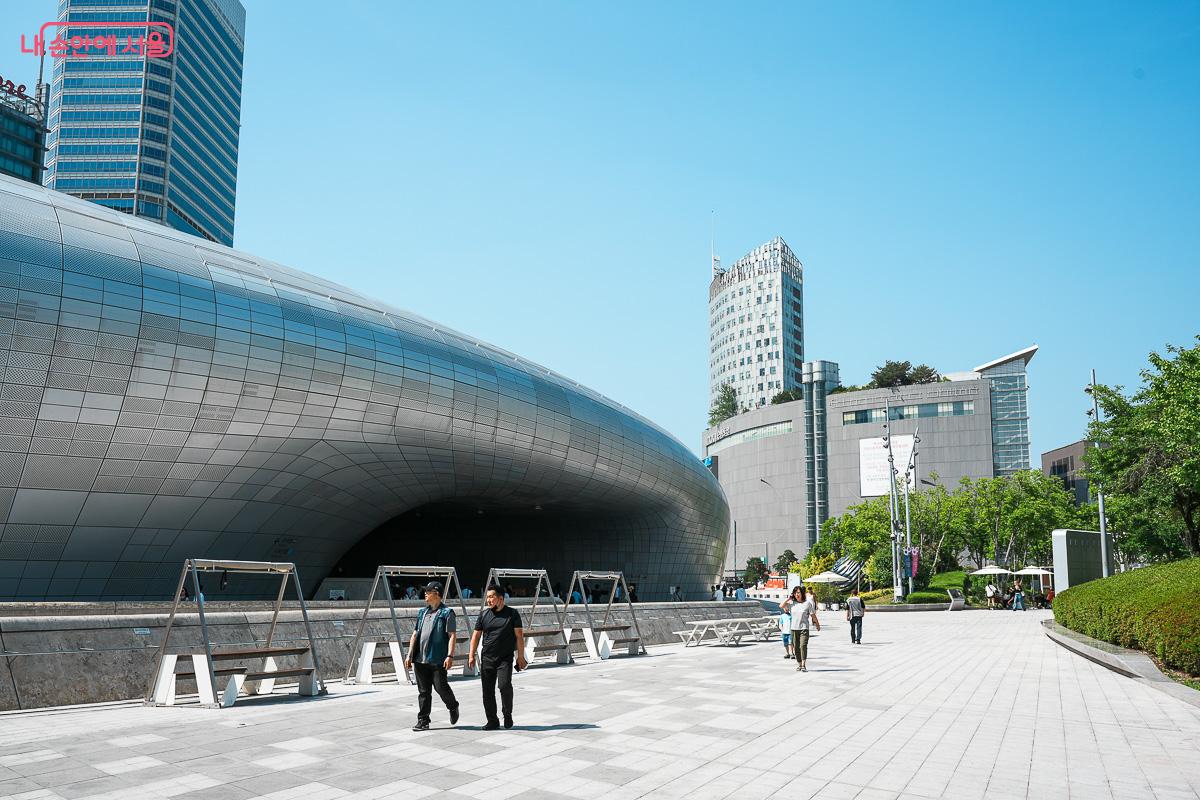 파란 하늘 아래 동대문디자인플라자(DDP) 전경, 그 주변을 걷는 시민들 모습
