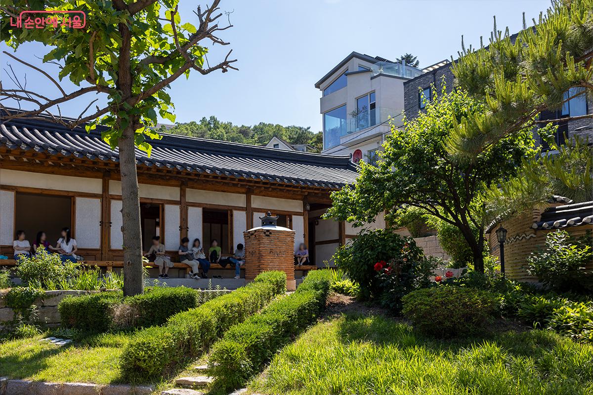정원에서 시민들이 한옥의 여유를 즐기고 있다.