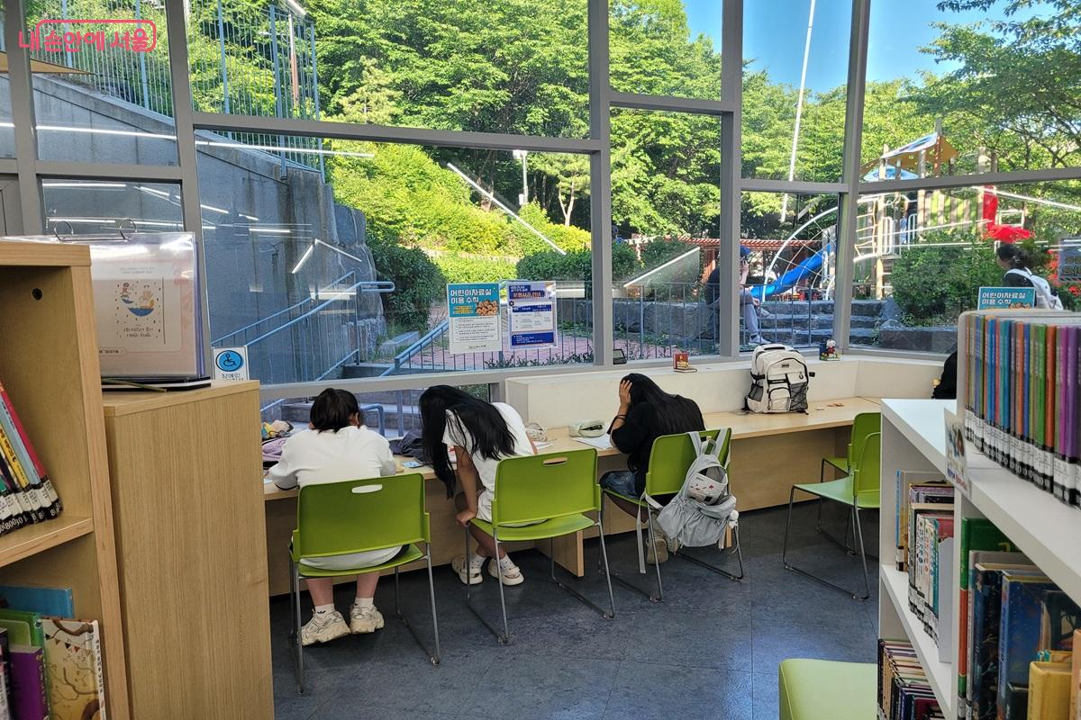 통창 너머 초록 풍경을 바라보며 아이들이 독서를 즐기고 있다. &copy;조연