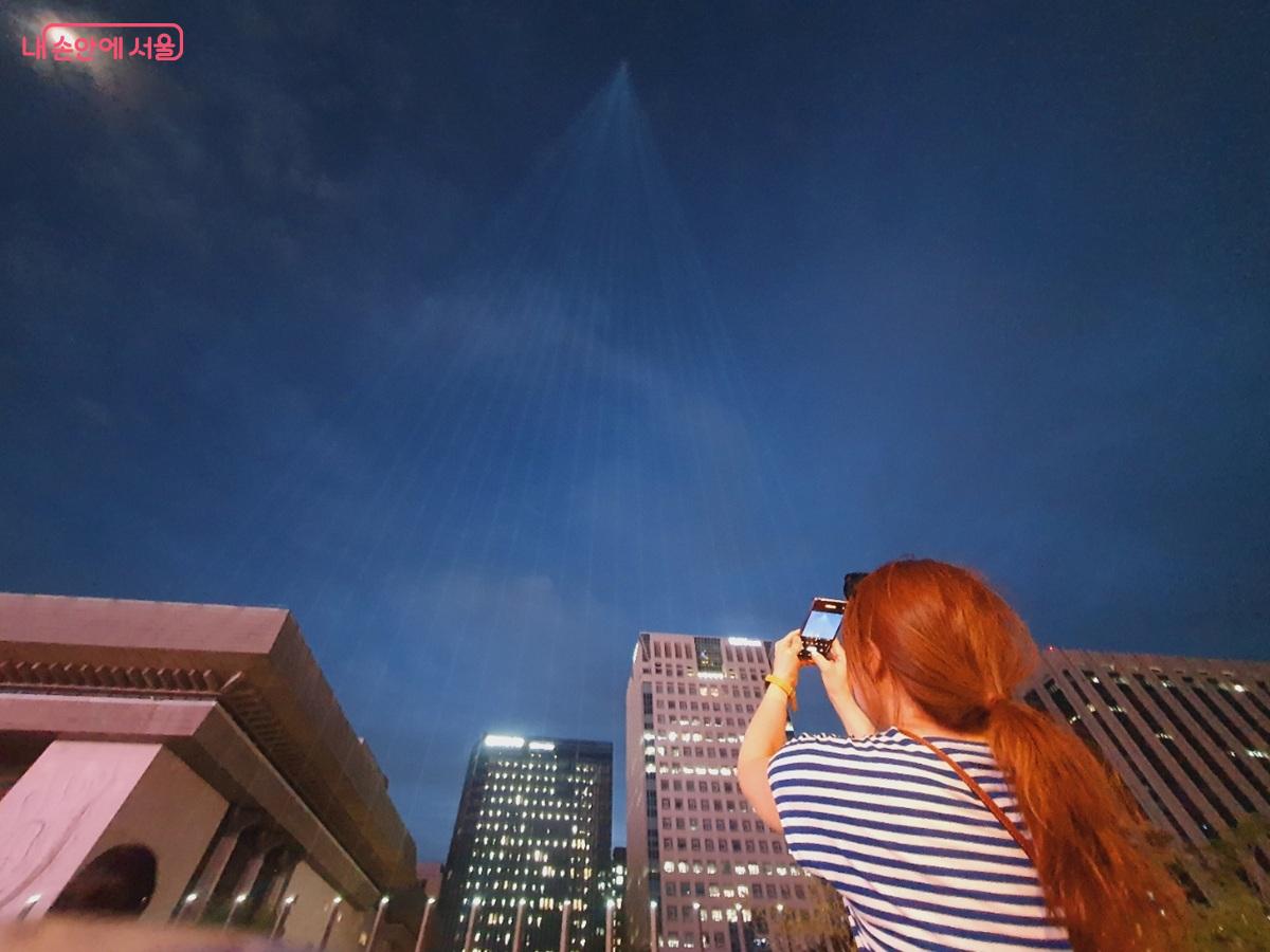 빛줄기가 서울 밤하늘 공중에서 하나의 꼭지점으로 모이는 장관이 연출된다. ©김병규