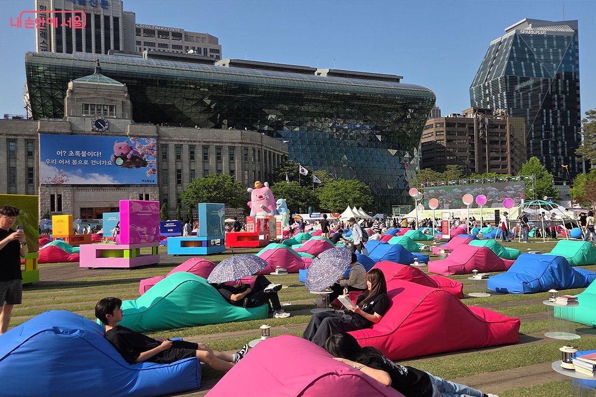 푸른 잔디밭 위 알록달록한 빈백에 누워 자유롭게 독서를 즐기는 시민들 &copy;이다현
