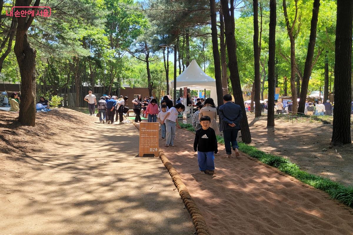 아이들이 자연 속 체험 공간에서 맨발로 흙길을 걷고 있다. &copy;조연