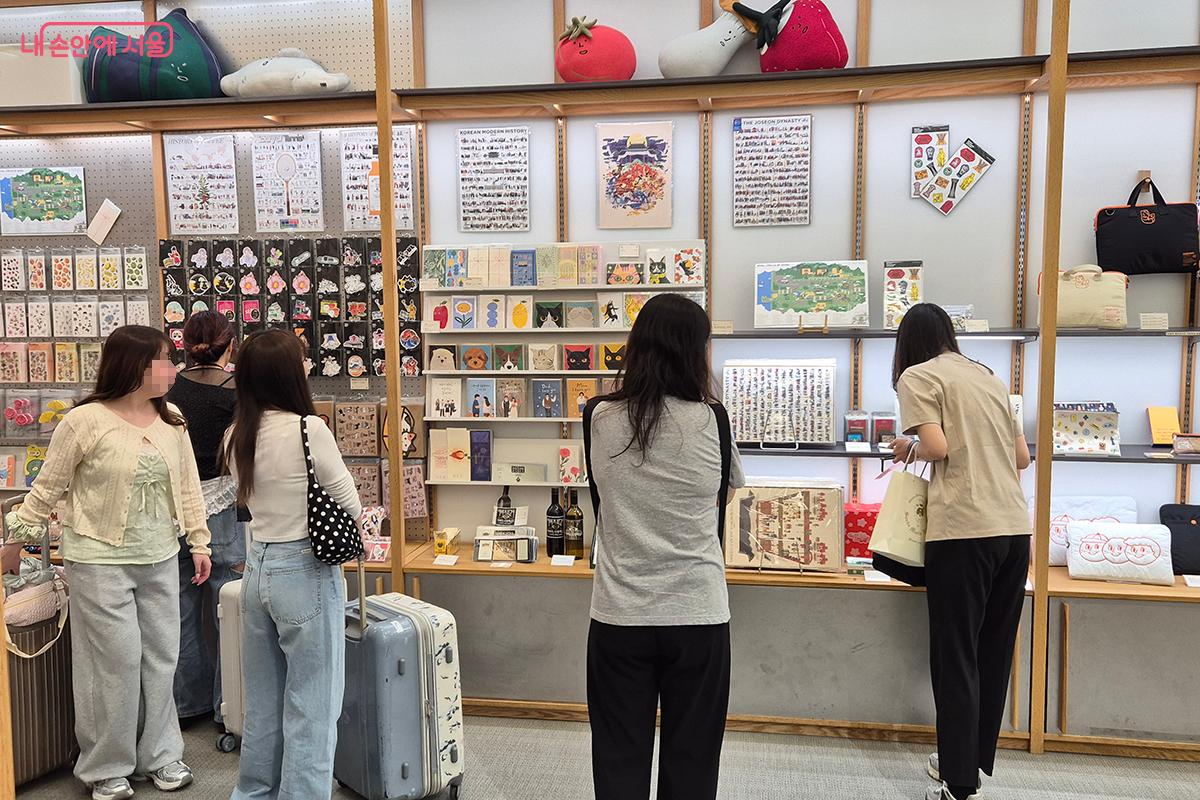 외국인 관광객들이 다양한 서울 굿즈를 구경하고 있다.