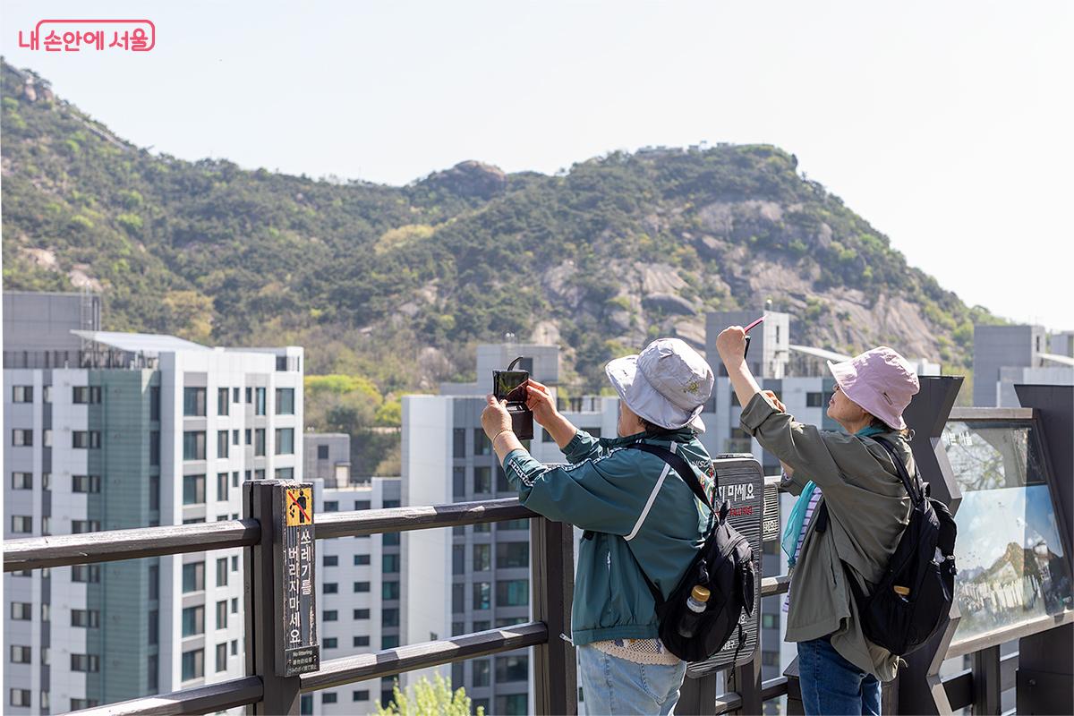 안산 자락길 전망대에서 멋진 풍경을 스마트폰에 담고 있는 시민들 &copy;문청야