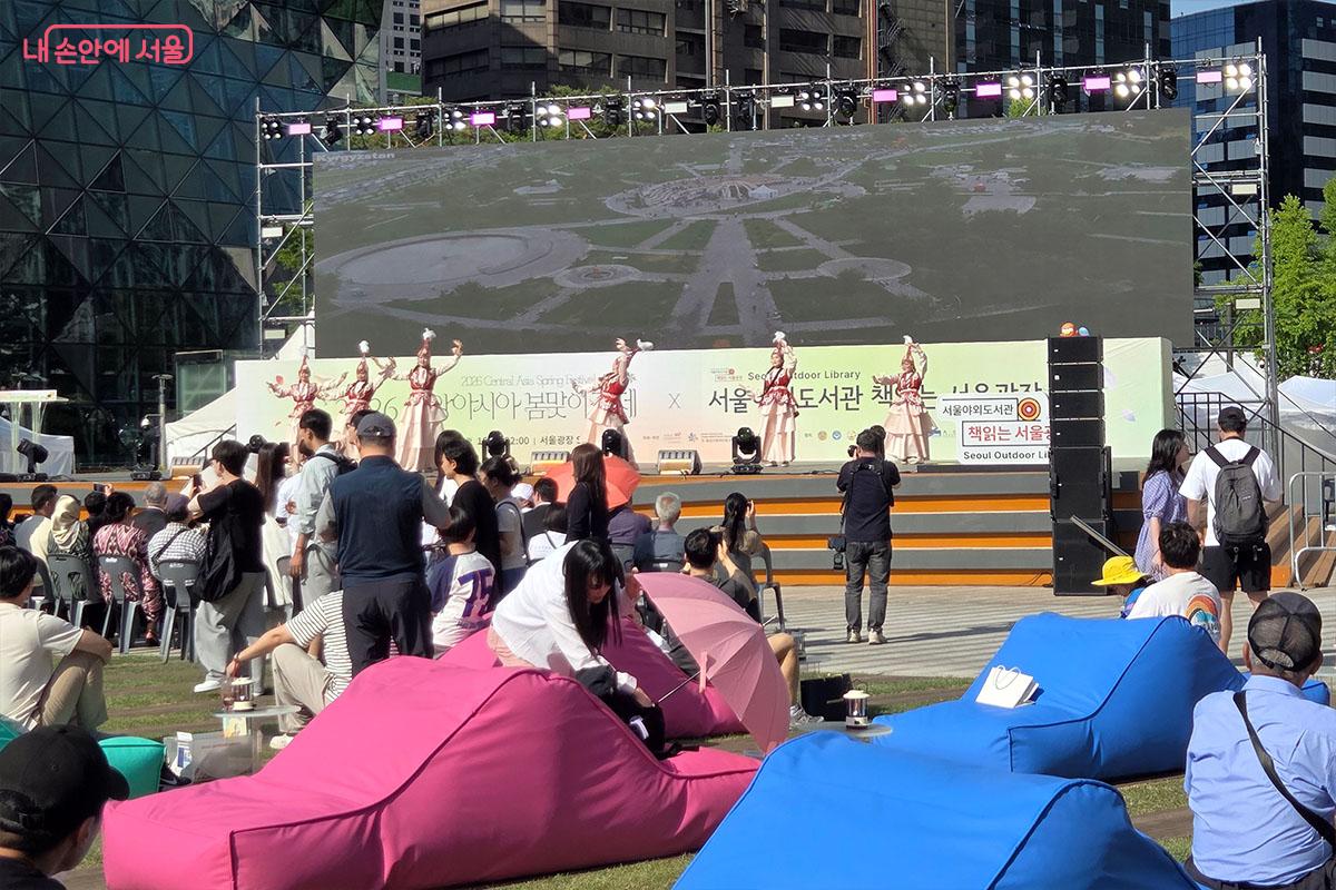 서울광장 메인 무대에서 펼쳐지는 중앙아시아 전통 춤 공연을 시민들이 잔디밭 빈백에 앉아 관람하고 있는 모습 &copy;이다현