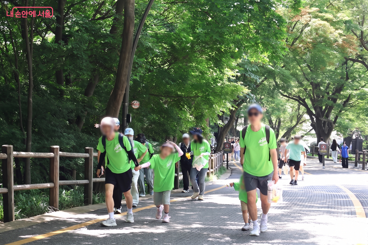 밀고 끌며 서로 손을 잡고 의지하며 걷는 가족들 &copy;이봉덕