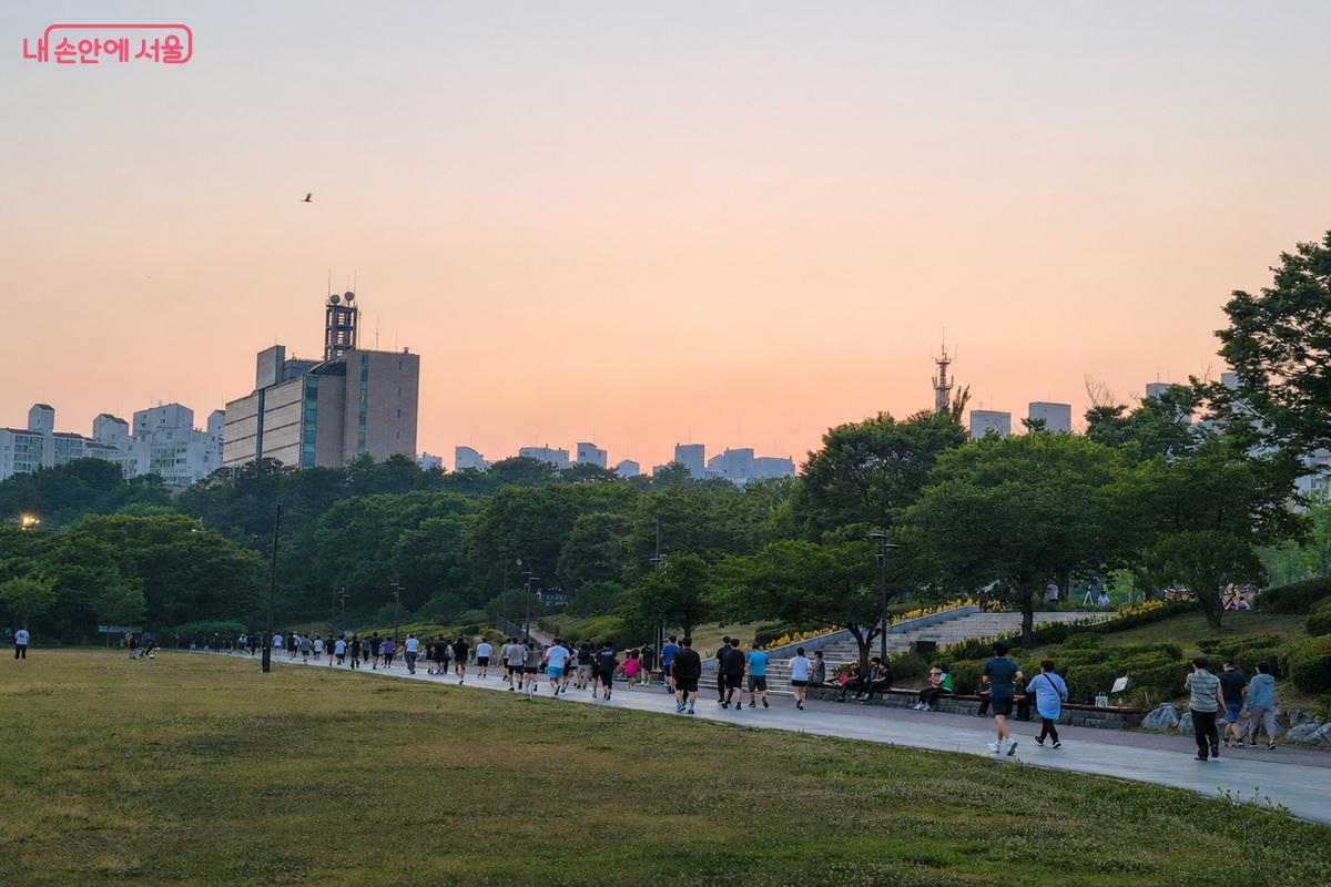 노을이 물든 보라매공원 산책로에서 걷기와 조깅을 즐기는 시민들