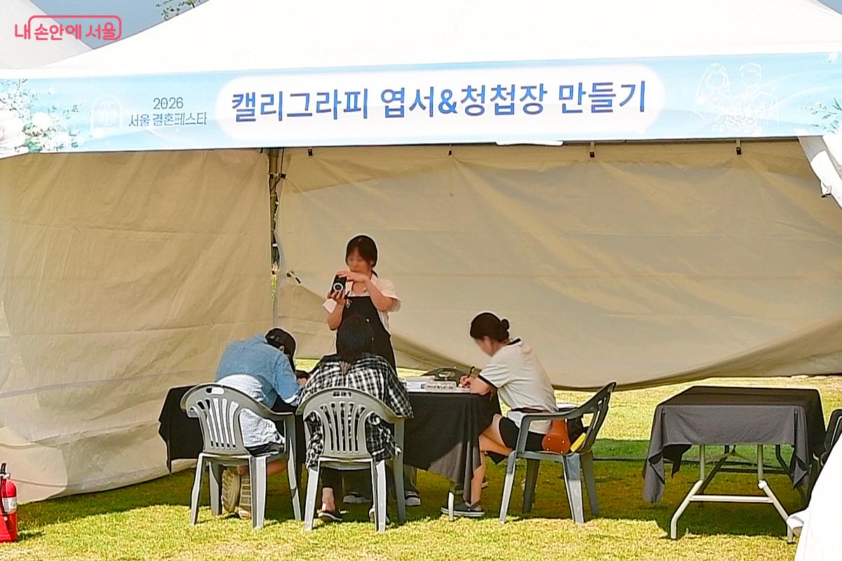 청첩장을 만들어 볼 수 있는 체험부스에서 직접 청첩장을 만드는 예비부부 