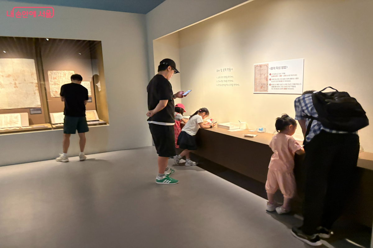 호적 만들기 프로그램에 가족 단위 관람객들이 참여하고 있다.