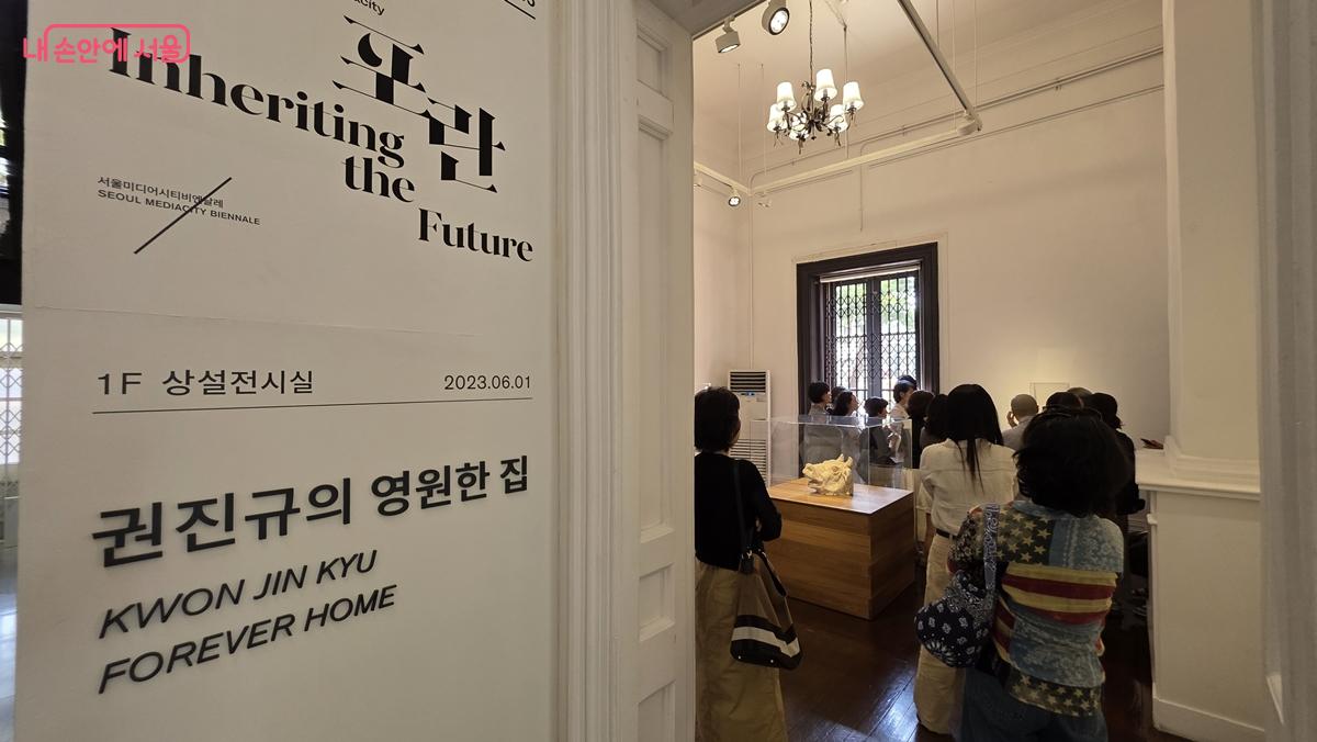 남서울미술관 복도에 게시된 전시 안내 및 관람객들