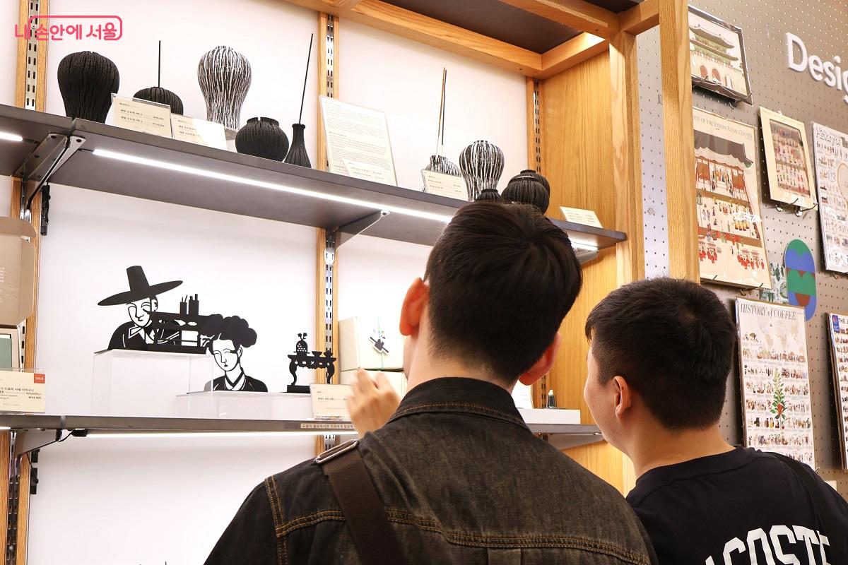 전통 한복 실루엣을 살린 현대적 철제 오브제와 도자 소품을 관람하는 청년들 &copy;이봉덕
