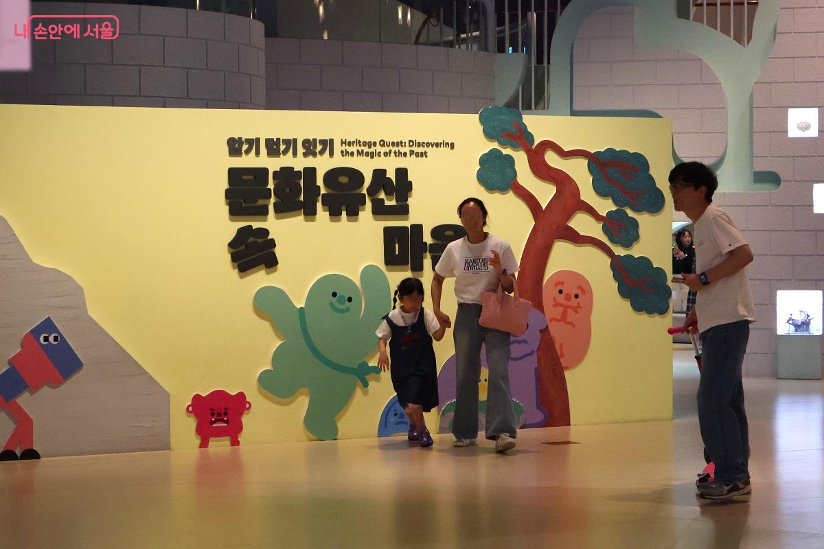 캐릭터 전시벽 앞을 지나는 활기찬 가족들 &copy;이봉덕