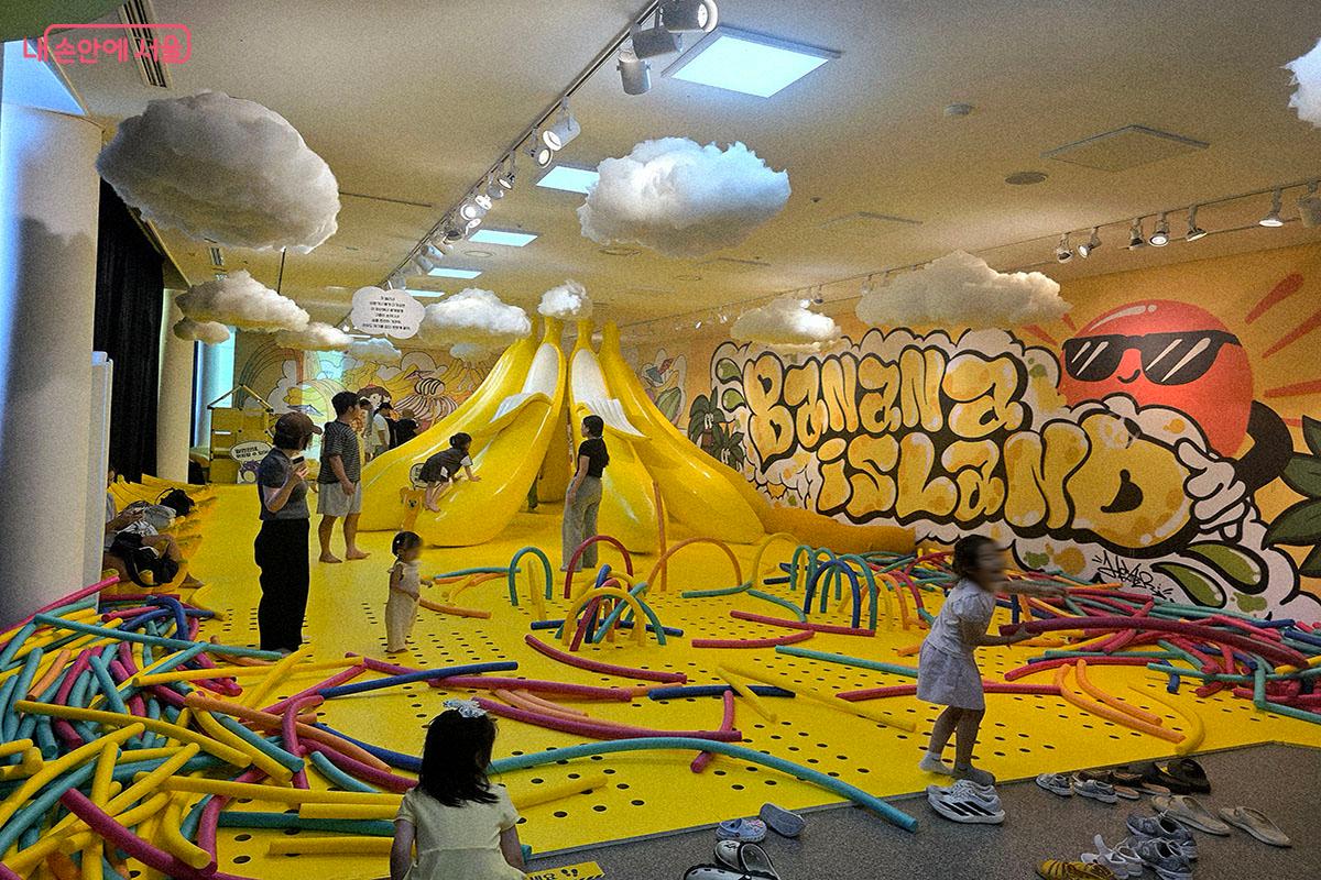 북서울꿈의숲 상상톡톡 미술관에서 열린 '빠씨를 찾아서'바나나 아일랜드 전시 체험장. 아이들이 노란색 공간에서 스티로폼 바와 바나나 모양 미끄럼틀을 타며 창의적인 신체 놀이를 즐기고 있다.ⓒ양순남