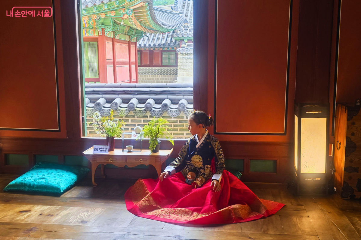 창덕궁 약방 내부의 열린 창가에 한복을 입은 관람객이 앉아 있다. ©양정화