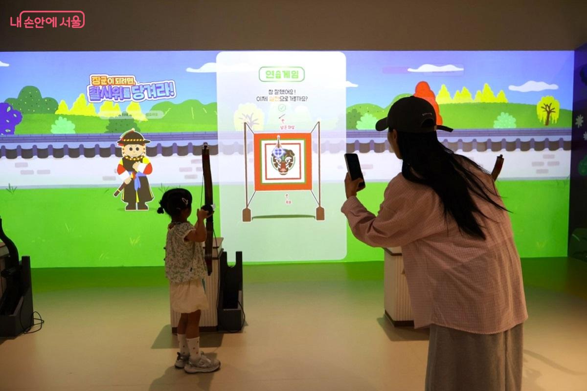 스크린을 보며 디지털 활쏘기 게임을 즐기는 모습 &copy;이봉덕