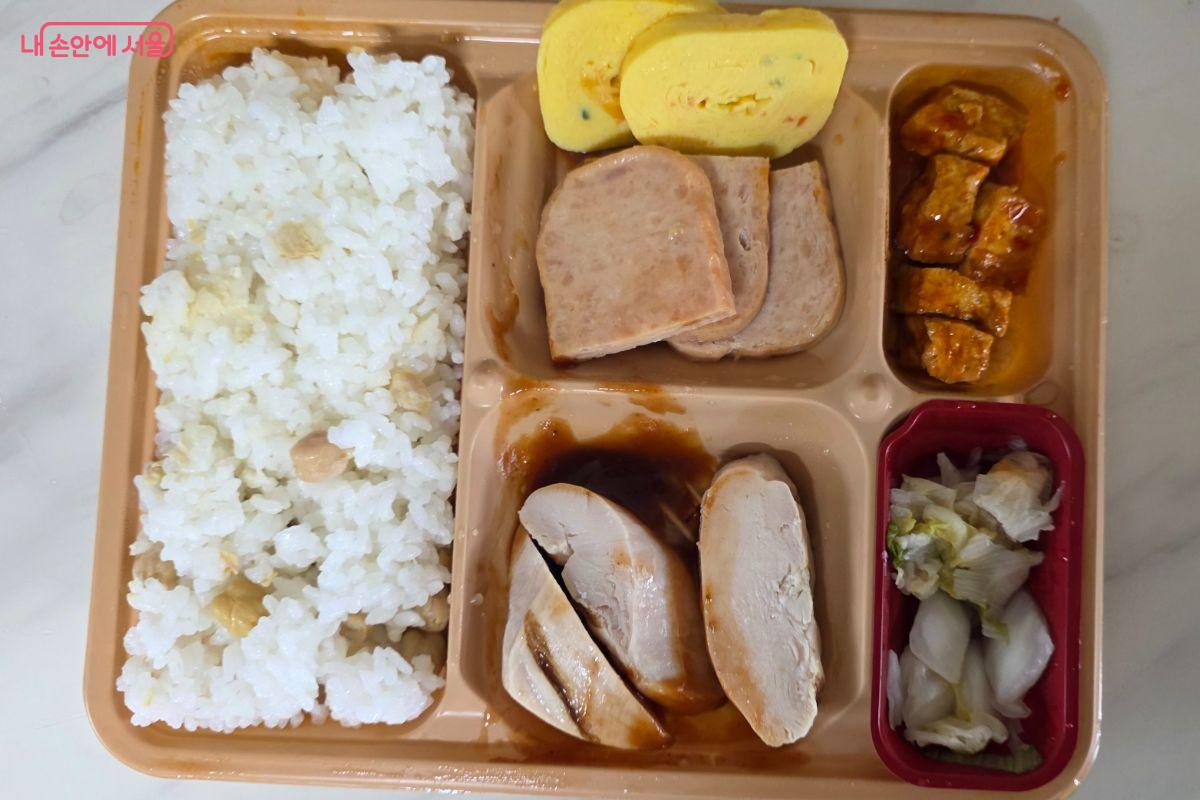 도시락의 반찬은 단백질이 풍부한 계란, 닭가슴살, 두부로 구성되어 있으며 저당 소스를 더해 맛있게 먹을 수 있도록 만들어졌다.