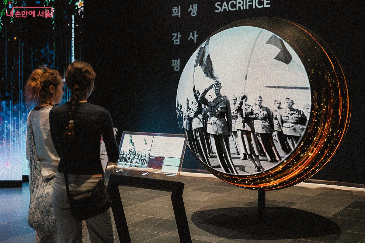사진으로 기록된 6.25전쟁의 순간들을 살펴보고 있는 관람객들 ©김아름