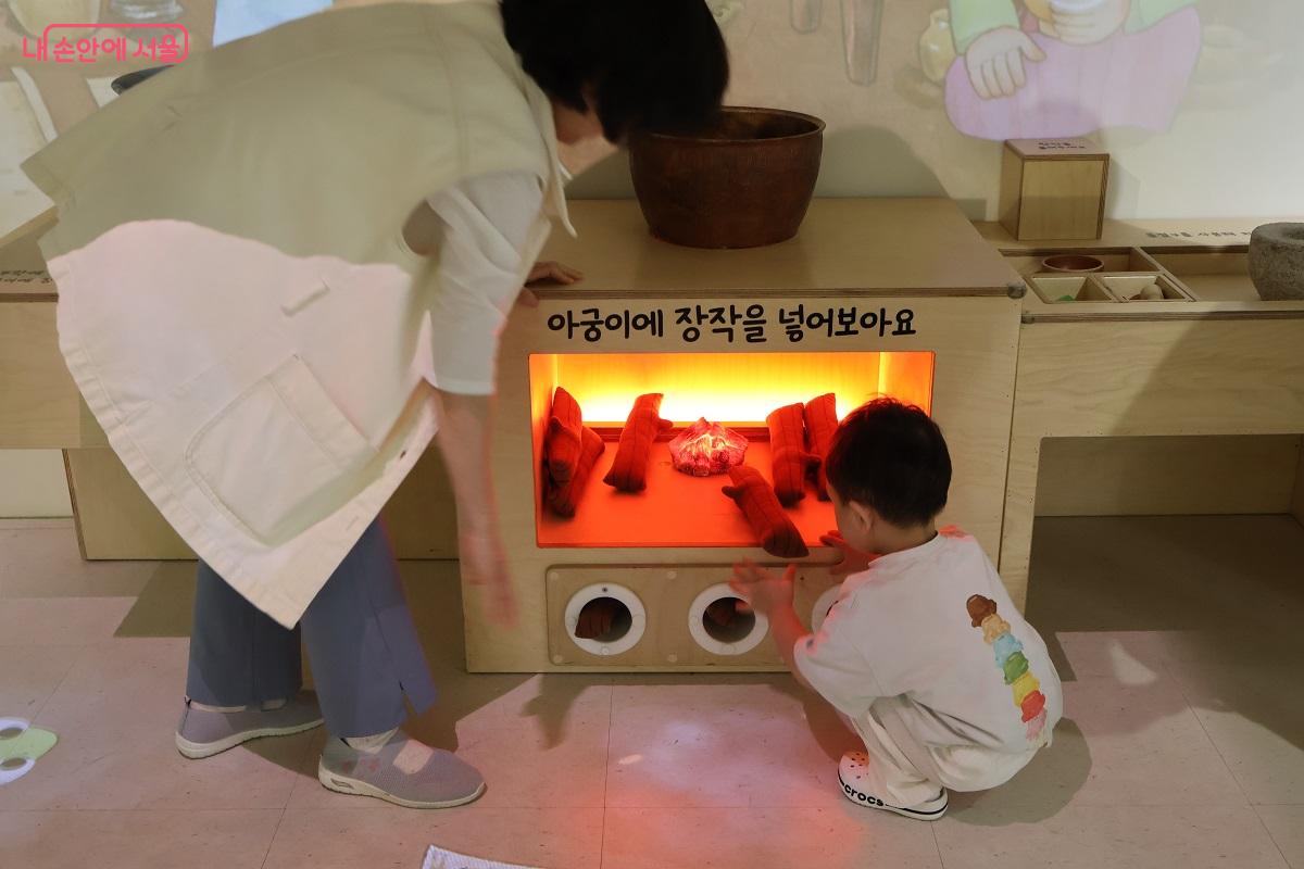 전통 아궁이 장작 넣기 체험 중인 아이 &copy;이봉덕