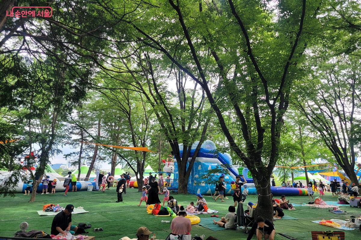 노원꿀잼워터파크에서 울창한 숲 그늘 아래 가족들이 휴식을 취하고 있다. ©조연