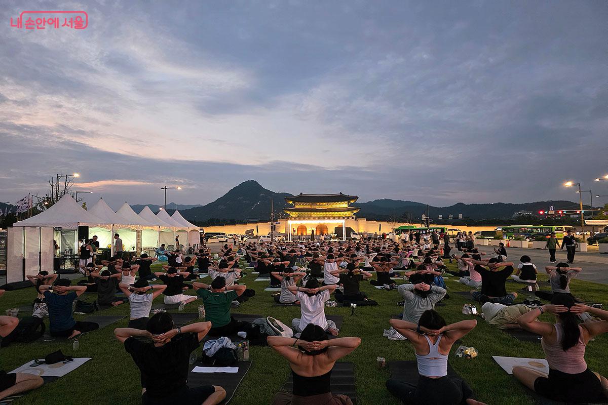 은은한 노을과 광화문 야경을 배경으로 다 함께 동작을 맞추며 힐링하는 '광화문 달빛요가' 현장