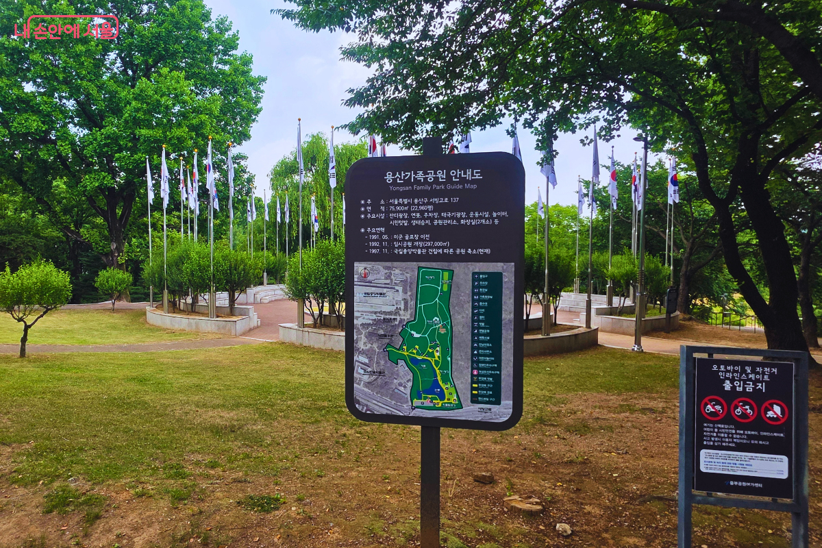 용산가족공원 안내도가 공원 한가운데 설치돼 있고 뒤편으로 여러 개의 태극기와 깃발이 늘어선 광장이 펼쳐져 있다.
