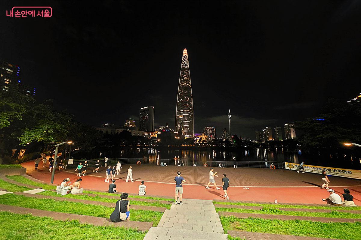 롯데월드타워가 우뚝 솟은 석촌호수 서호 수변 트랙에서 시민들이 산책을 즐기고 있다. &copy;양순남