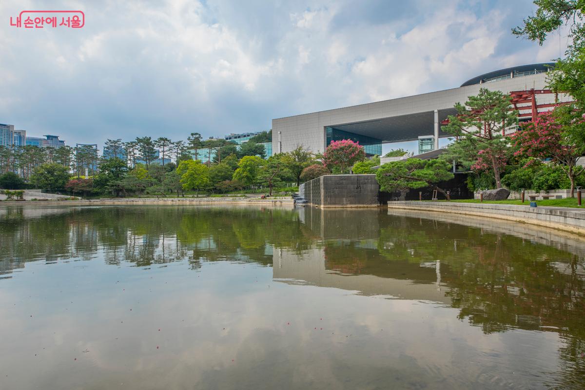 국립중앙박물관 앞의 거울못에 반영된 박물관과 배롱나무꽃 풍경.