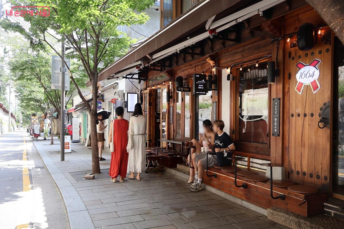 돌담과 한옥 카페 거리를 걷고 야외 토방에 앉아 여유를 만끽하는 방문객들 ©이봉덕