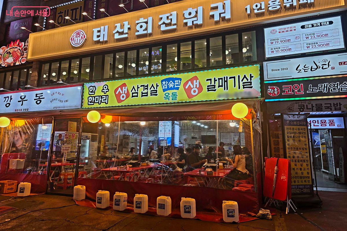 식당 앞 야장 천막을 가득 채운 시민들이 식사와 음료를 나누며 하루의 피로를 풀고 있다.&copy;양순남