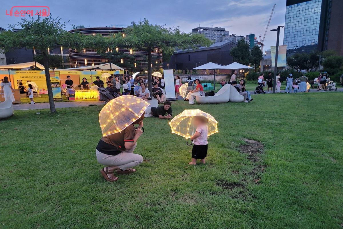 별빛 우산을 든 시민들이 눈높이를 맞추며 즐거운 시간을 보내고 있다. ©조연