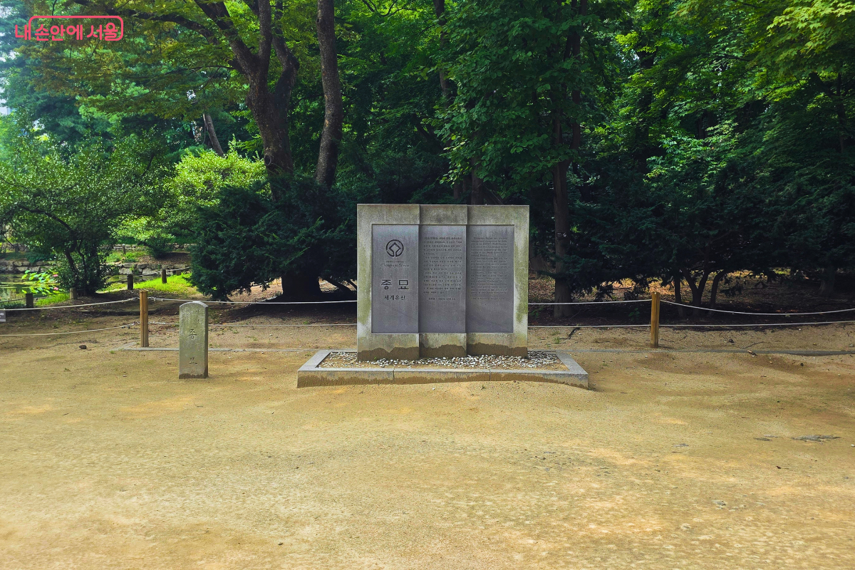 울창한 숲을 배경으로 유네스코 세계유산임을 알리는 종묘 표석이 세워져 있다.