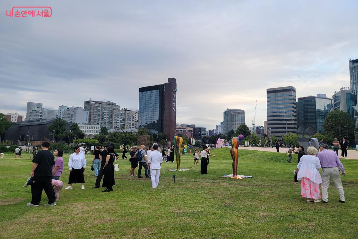 열린송현녹지광장 잔디밭에서 다양한 조각 작품을 감상하고 사진을 찍는 시민들 ©조연