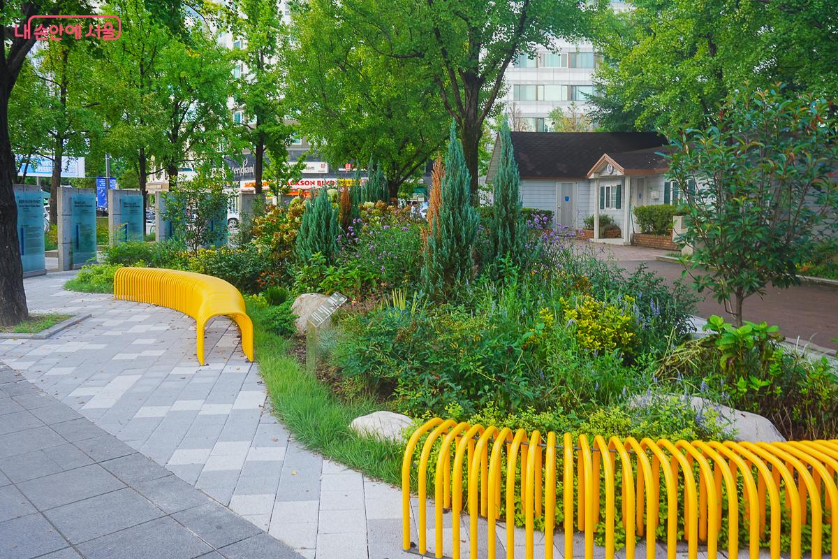 정원 산책로를 따라 노란색 곡선형 벤치와 다양한 초화가 어우러져 있다 ,©김성무