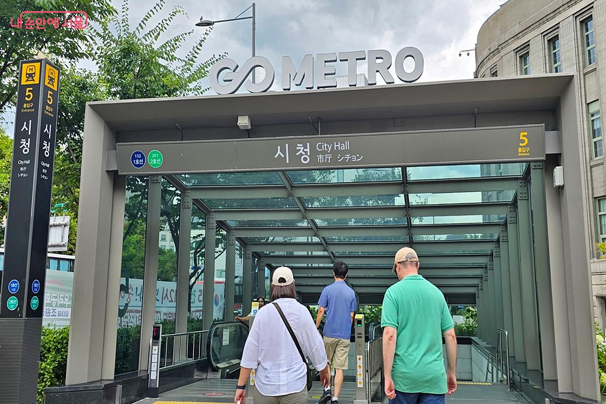 ‘고서울(GO SEOUL)'이 쓰여진 시청역을 지나는 관광객들 ©김윤경