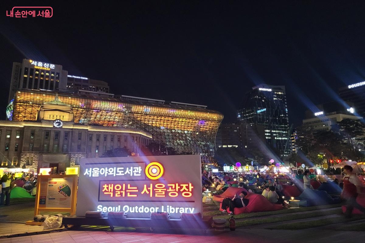 9월 4일 하반기 운영을 시작한 ‘책읽는 서울광장’ 뒤로 서울시청이 조명을 밝히고 있다. ©조연