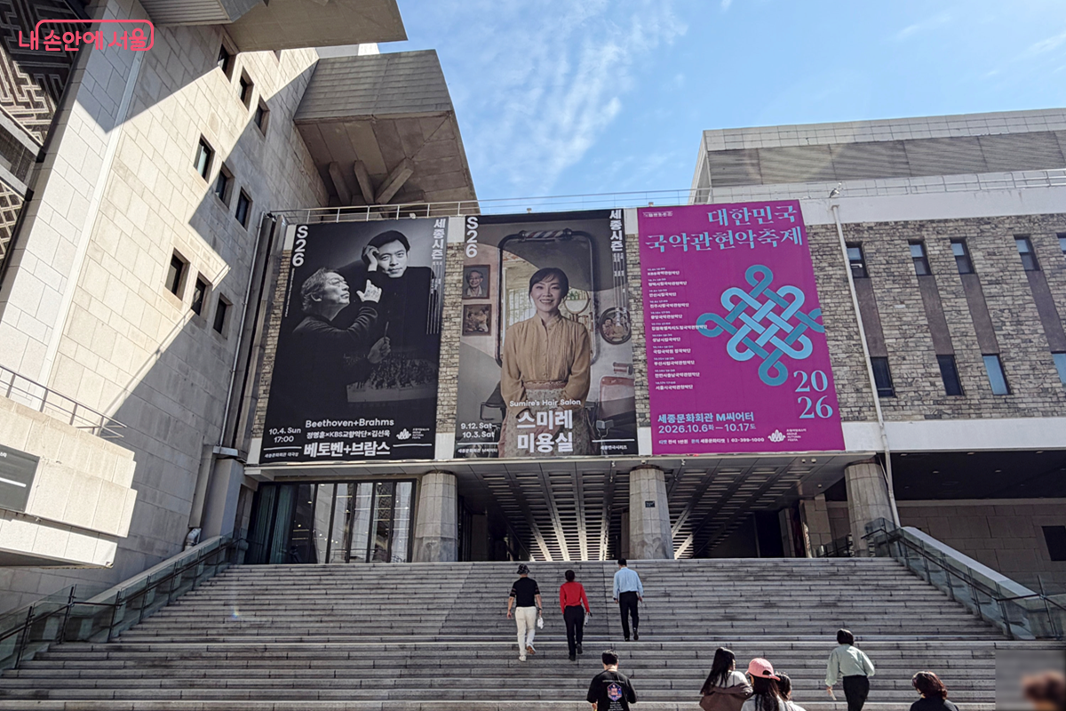 세종문화회관 외부를 이동하는 참가자들 위로 공연 포스터가 보인다. © 김경선