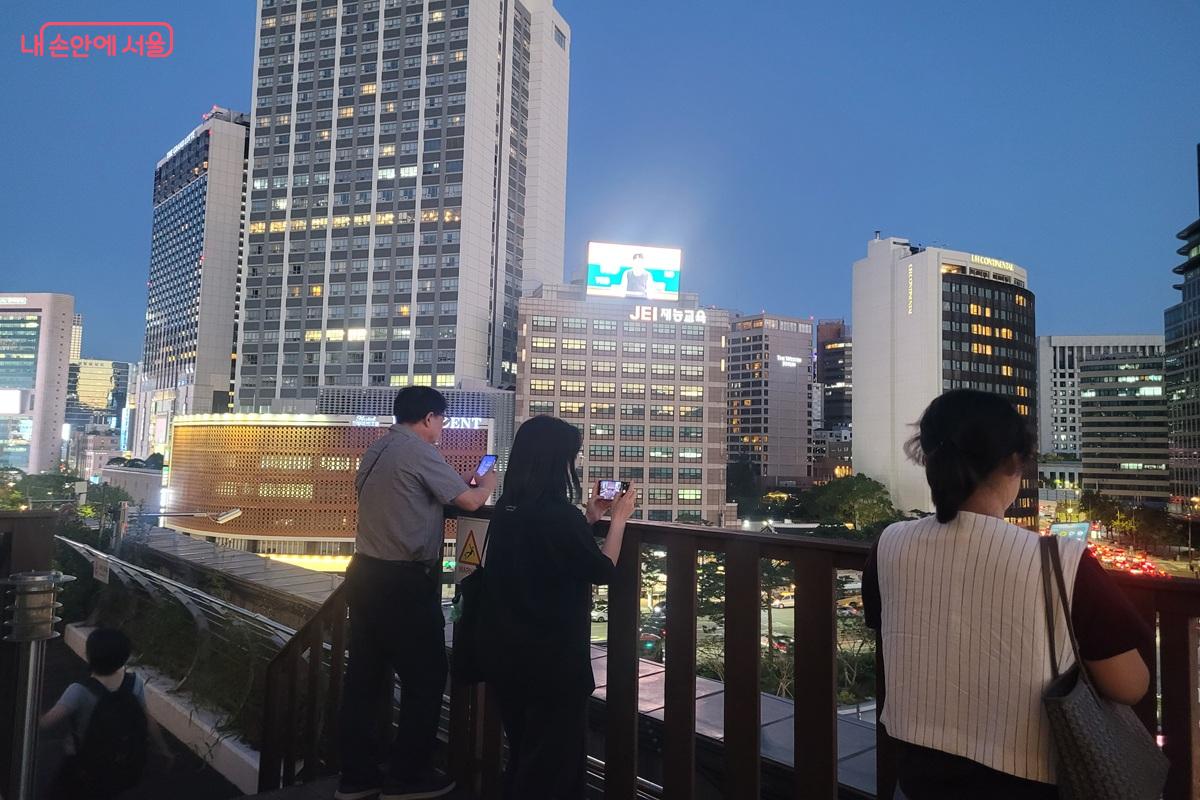 해 질 무렵 서울도서관 '하늘뜰'에서 시민들이 도심의 풍경을 바라보고 있다. ©조연