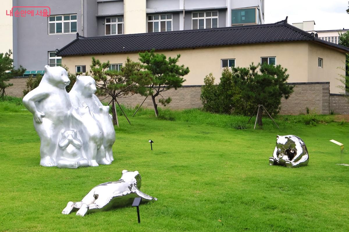 푸른 잔디밭 위에서 놀고 있는 은색 곰 가족 조각들 &copy;이봉덕