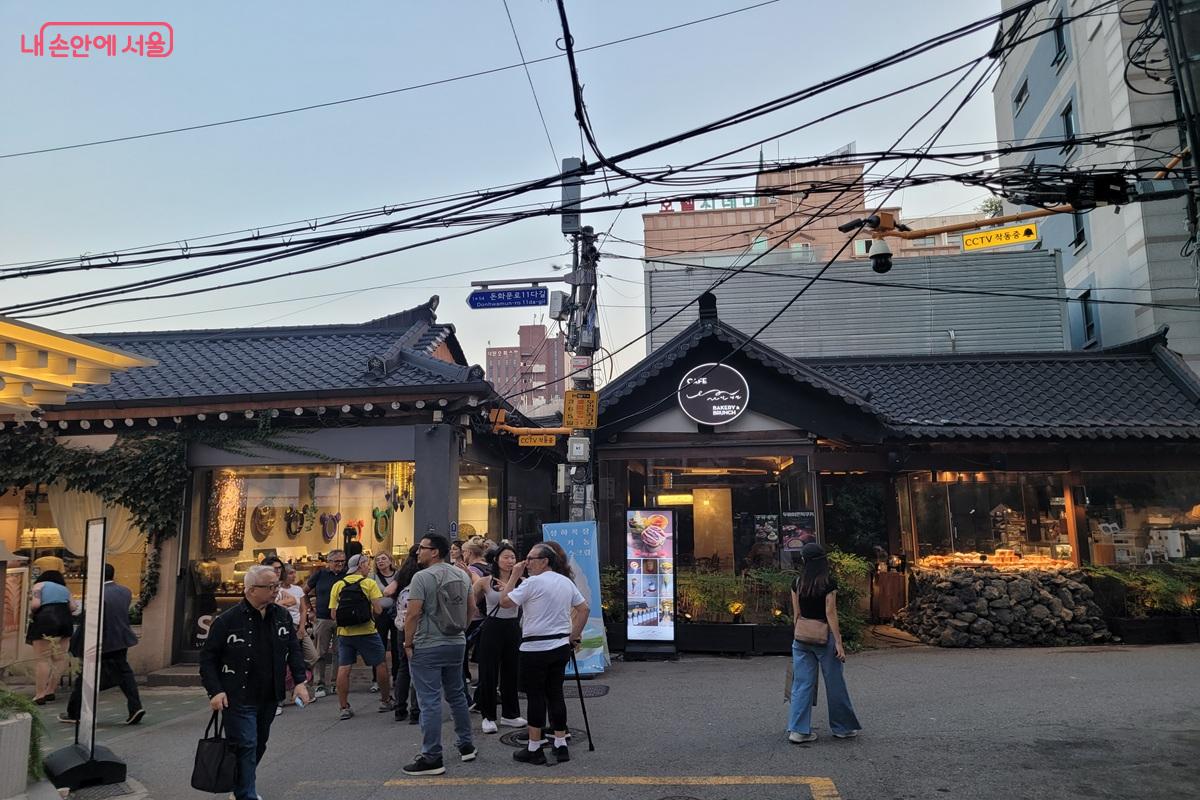 한옥을 개조한 카페와 상점 앞에 여러 외국인 관광객이 모여 익선동을 둘러보고 있다. &copy;조연