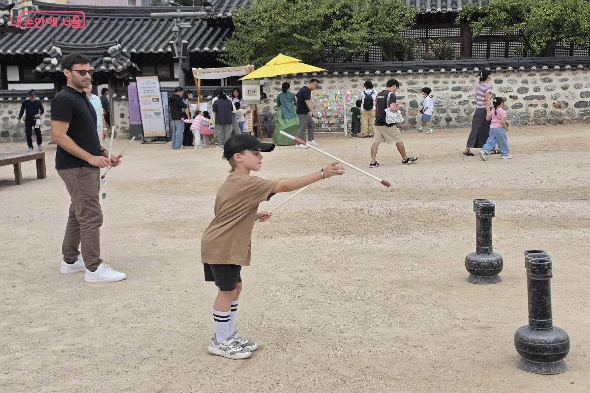 외국인 관광객이 전통놀이인 투호를 체험하고 있다. ⓒ심재혁