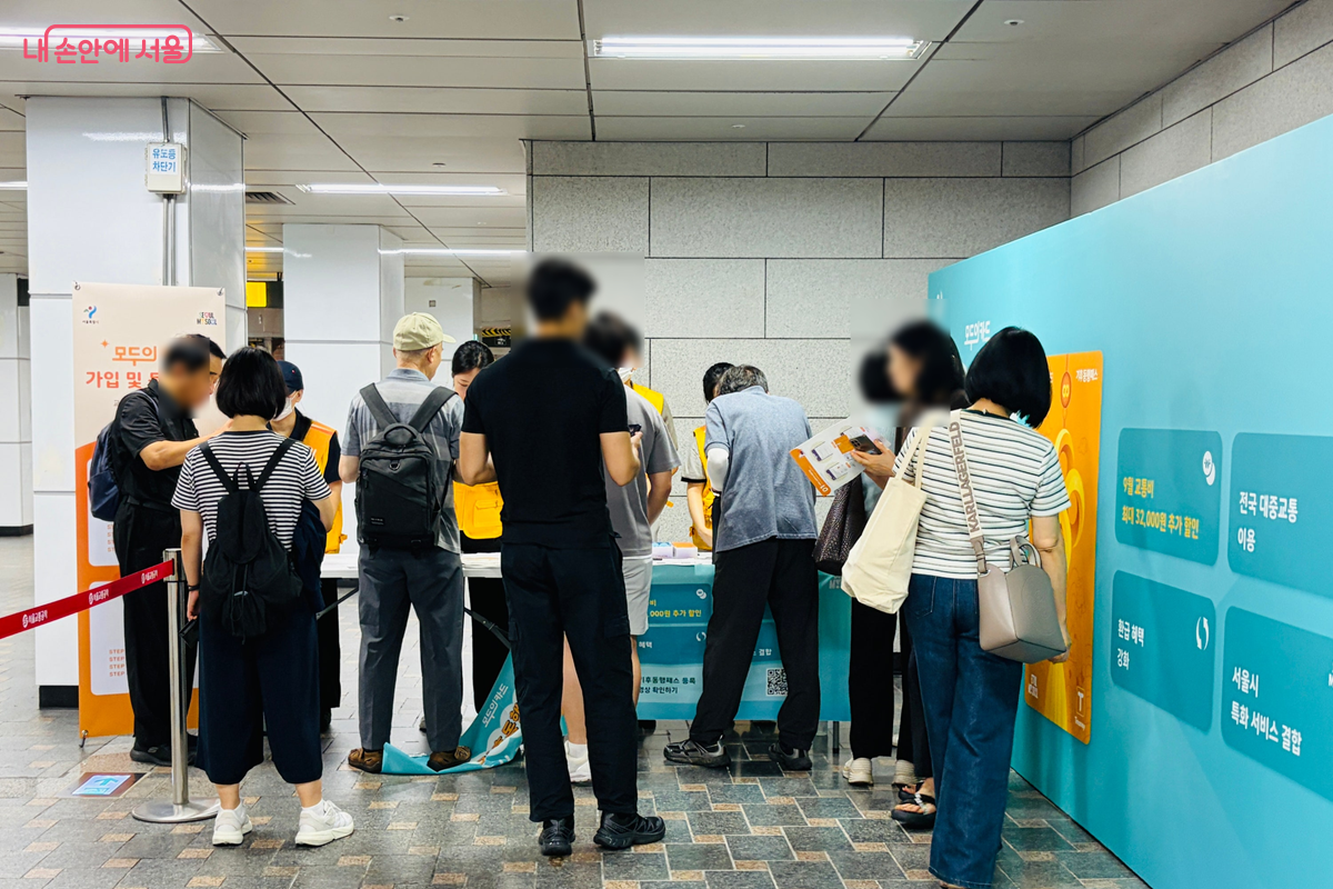'기후동행패스' 가입·등록을 위해 시민들이 시청역 홍보부스 앞에 줄지어 서 있다. ©김경선