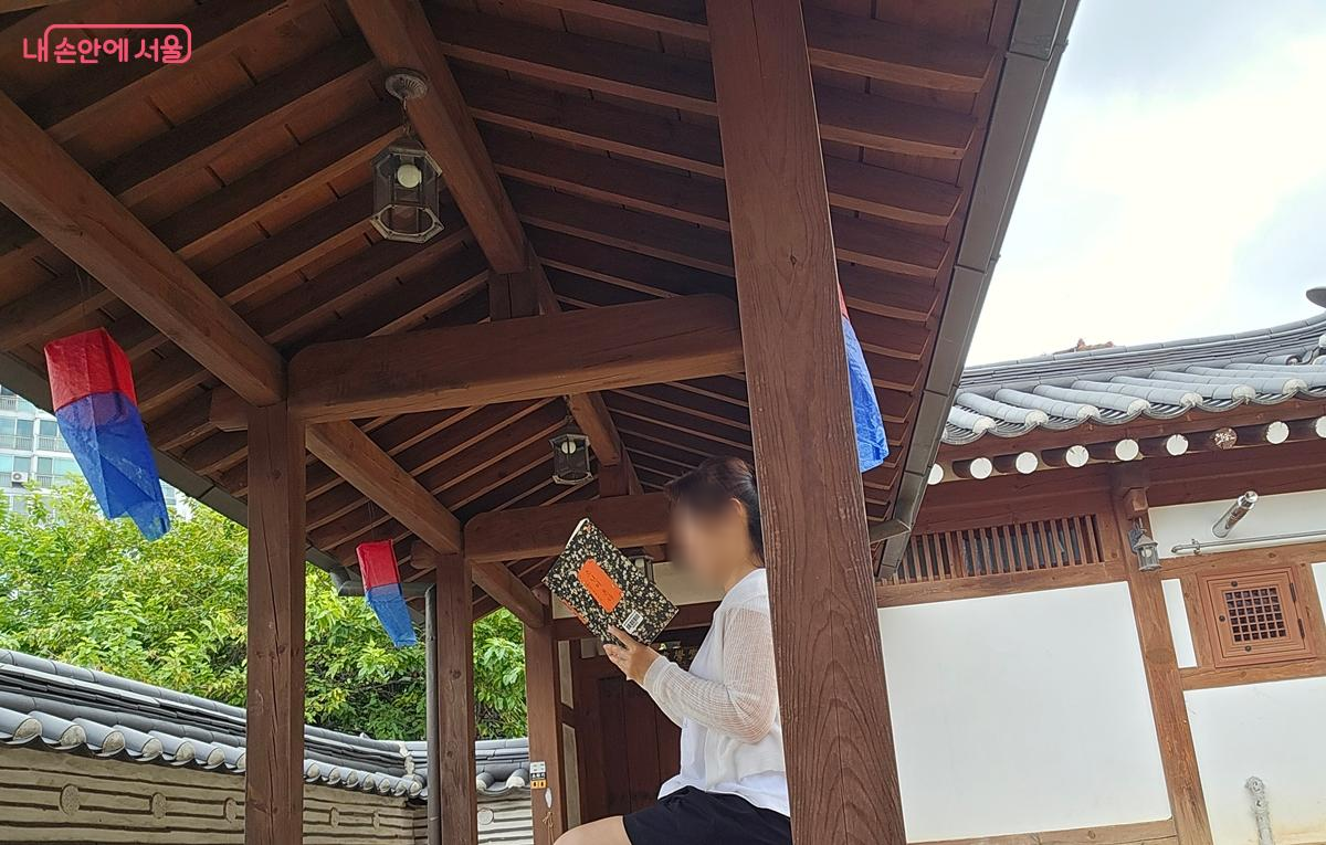 글마루한옥어린이도서관 야외 의자에서 책을 읽고 있다. &copy;조성희