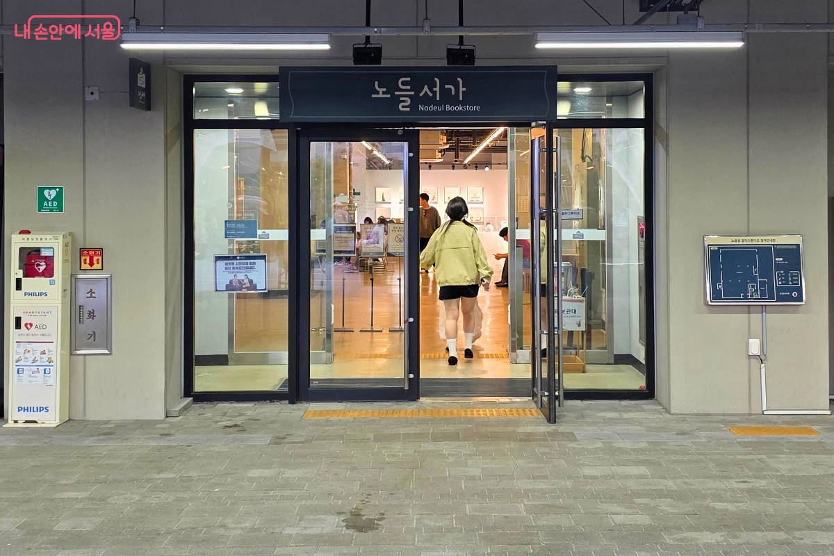 ‘노들서가’라고 적힌 아래 유리문이 활짝 열려 있고, 시민들이 출입하고 있다.